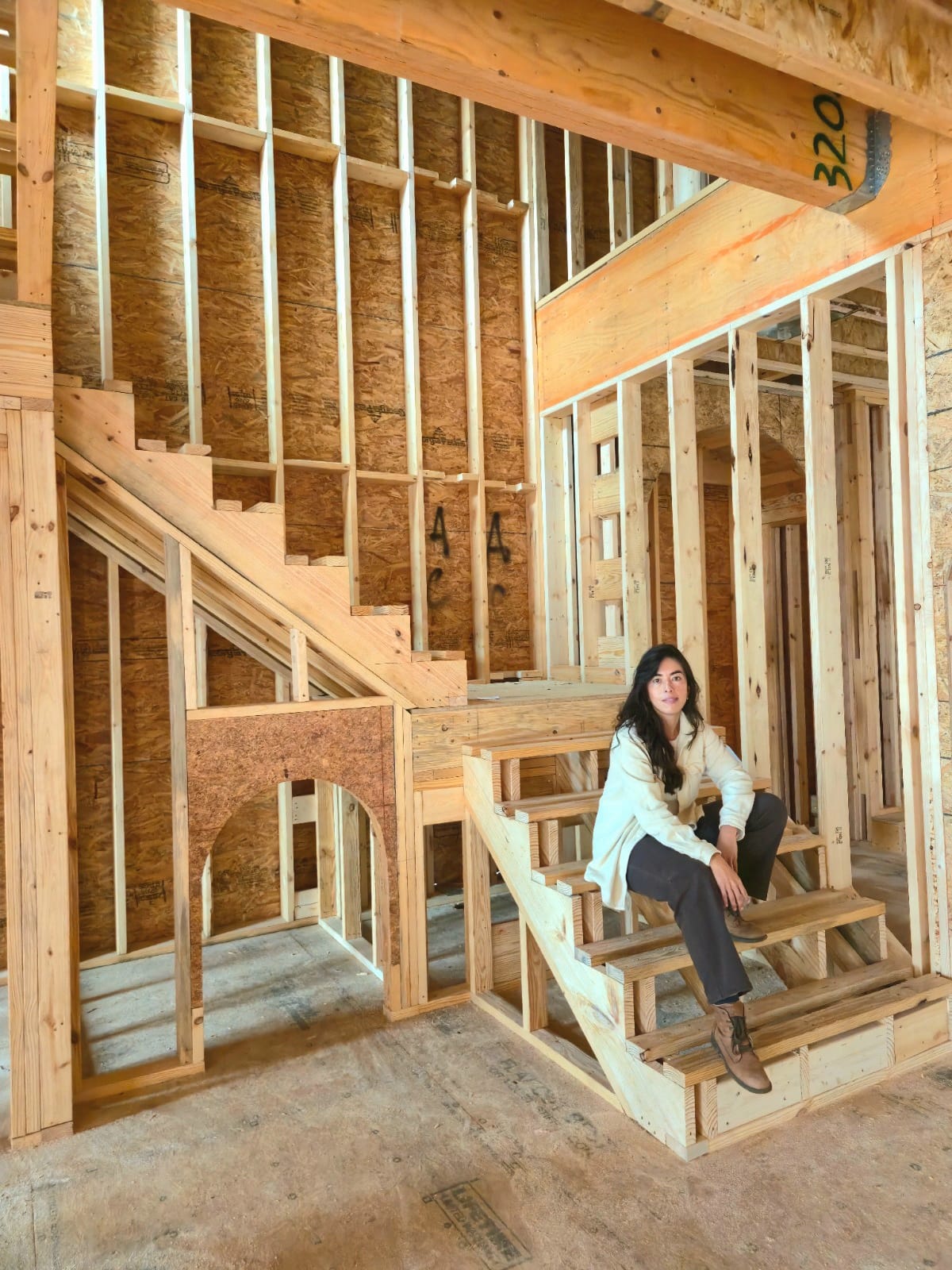 Jessica Granada sentada en las escaleras de una casa en construcción